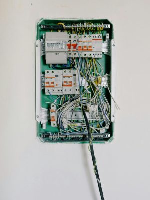 Detailed view of an open electrical circuit box with complex wiring and circuit breakers.